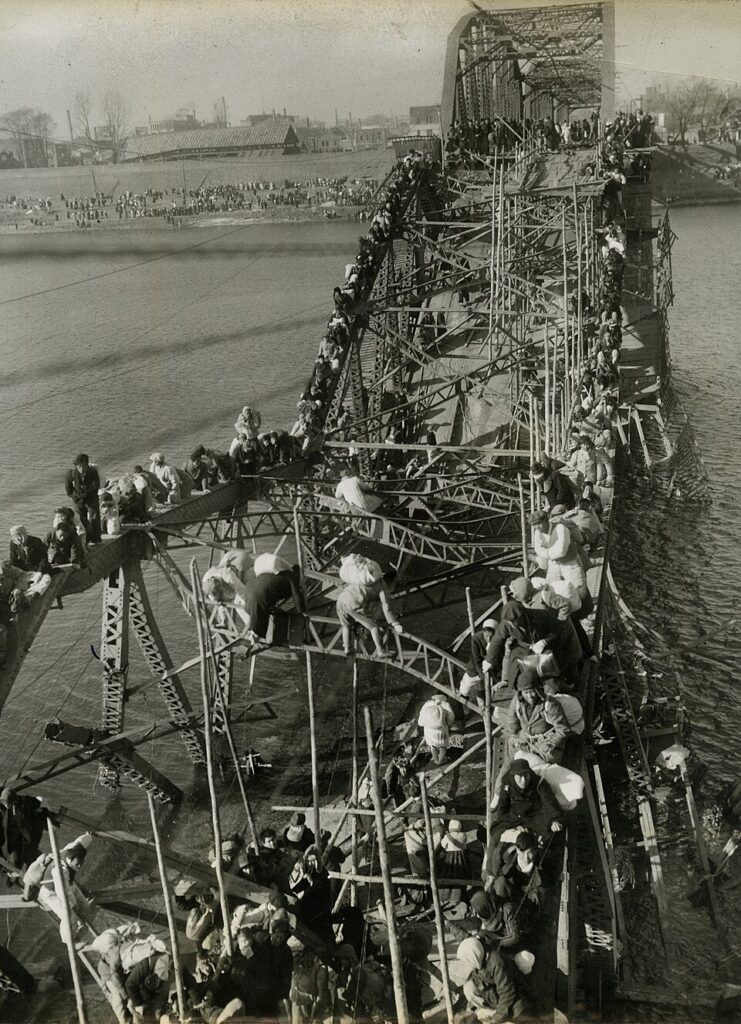 flight of refugees across wrecked bridge in korea